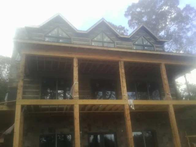 Dormers and porch framing on a large log home under construction — Roof Coating work by our crew in Spartanburg