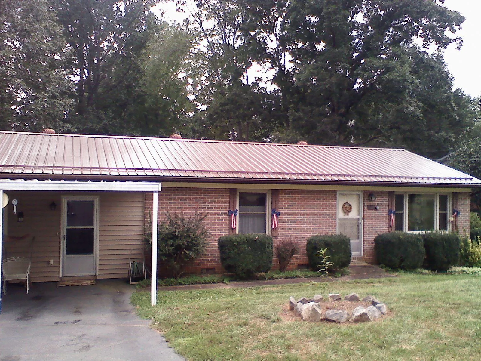 Bronze metal roof and carport on a brick ranch home — Roof Repair work by our crew in Spartanburg